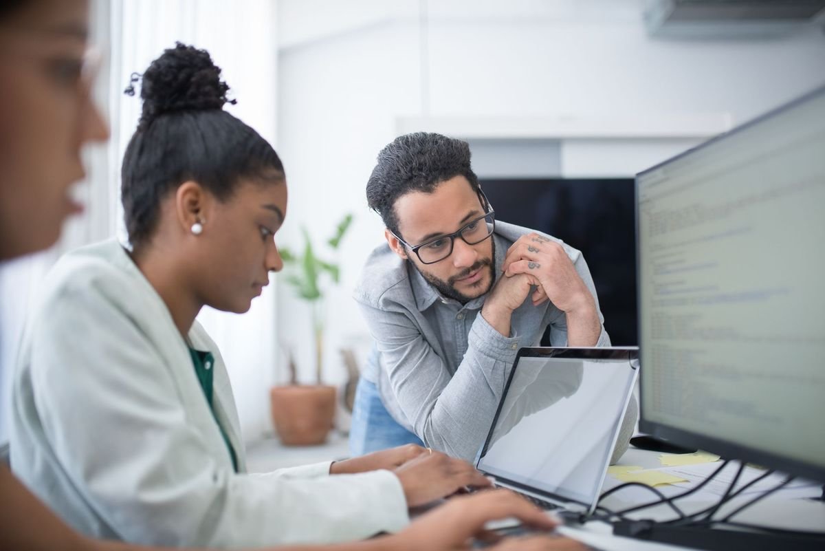 Two people discussing work together at a screen