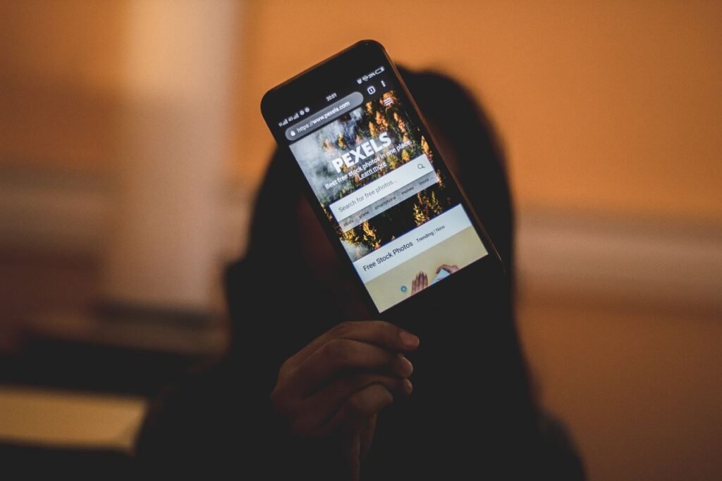 A person holding a smartphone displaying a website on its screen