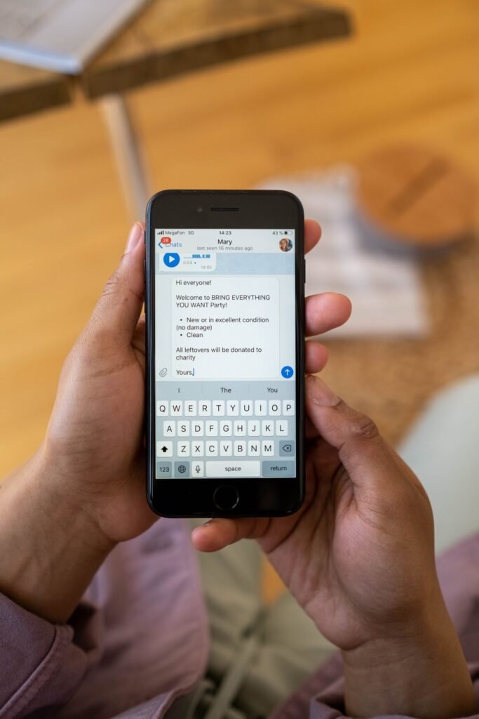 Close-up of hands holding a smartphone and typing a text message indoors
